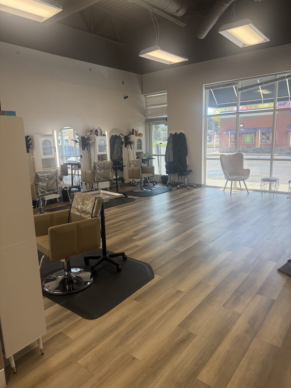 Hair station with lit mirror and styling chair by the front windows
