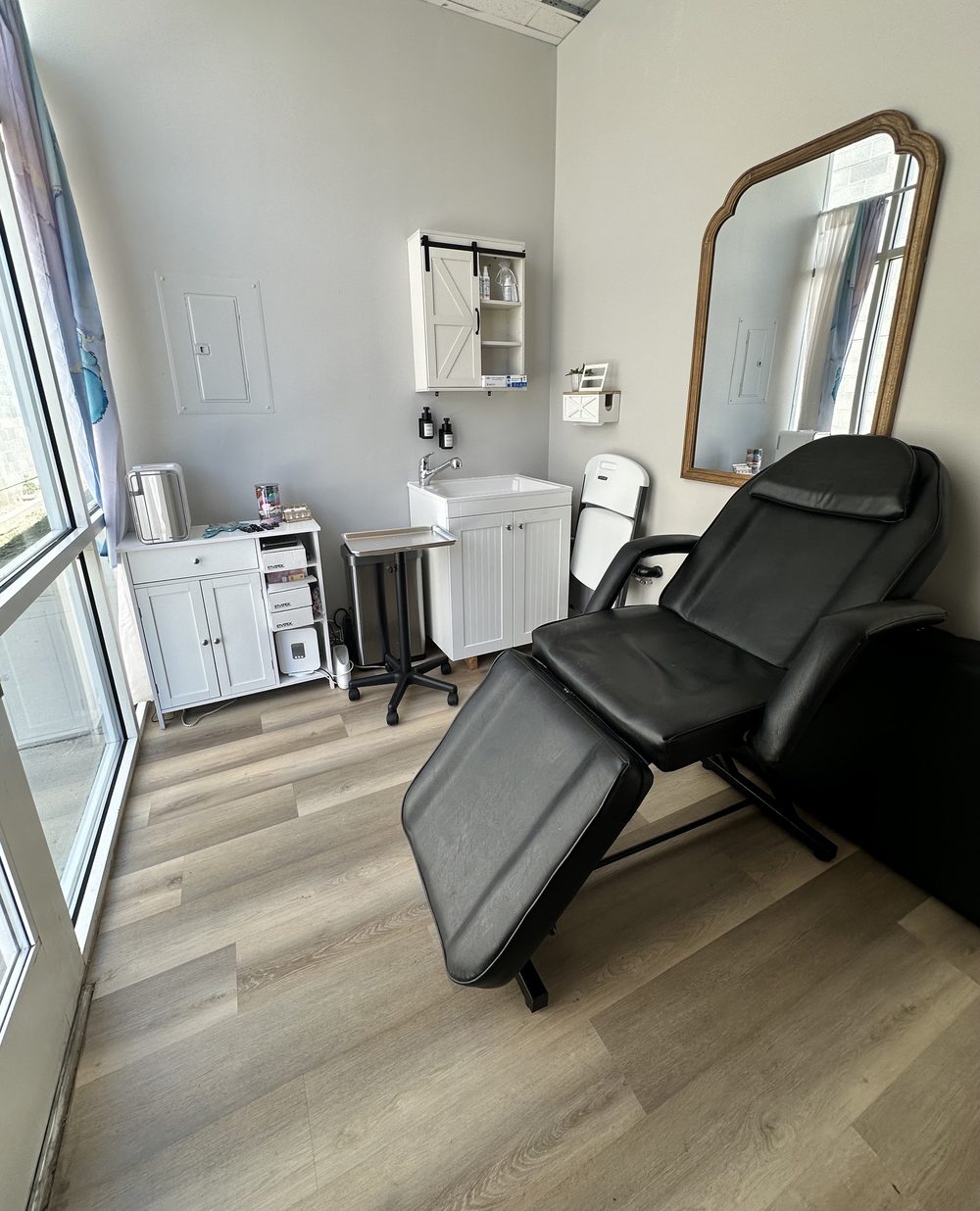 Private room with facial chair and gold mirror